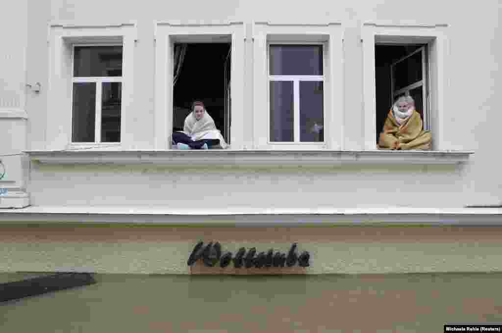 Людзі сядзяць у вокнах сваіх затопленых дамоў у нямецкім горадзе Пасау