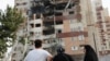 Iran - People look at a damaged building in the aftermath of Israeli strikes, in Tehran, June 13, 2025. 