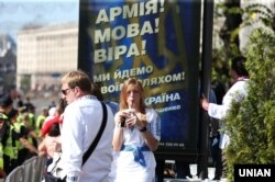 Дівчина біля рекламного плаката на Хрещатику під час параду військ з нагоди Дня Незалежності України. Київ, 24 серпня 2018 року
