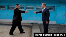 Lideri verikorean, Kim Jong Un (majtas) dhe presidenti jugkorean Moon Jae-in në zonën kufitare mes dy Koreve.