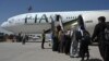 Passengers board a Pakistan International Airlines (PIA) flight, the first commercial international flight since the Taliban retook power last month, at the airport in Kabul on September 13.