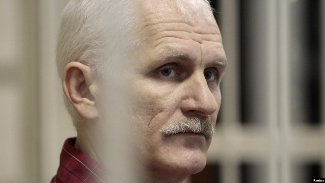 Human rights activist Ales Byalyatski sits in a guarded cage in a courtroom in Minsk during his trial in November 2011.