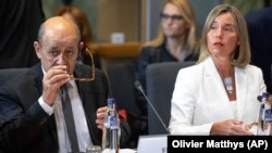 BELGIUM -- European Union foreign policy chief Federica Mogherini, right, sits next to France's Foreign Minister Jean-Yves Le Drian, during a meeting of the foreign ministers from Britain, France and Germany with the Iran Foreign Minister, at the Europa