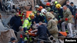 Рятувальники та волонтери виносять поранених з-під завалів житлового будинку, по якому влучила російська ракета. Прилуки, Україна. 7 жовтня 2026 року