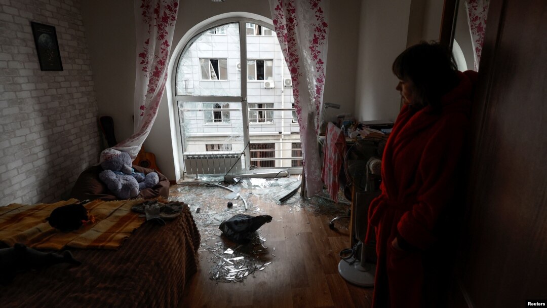 Local resident Kateryna stands inside a room of her apartment damaged by debris from a downed Russian drone in Kyiv on December 30.