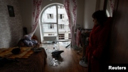 Local resident Kateryna stands inside a room of her apartment damaged by debris from a downed Russian drone in Kyiv on December 30.