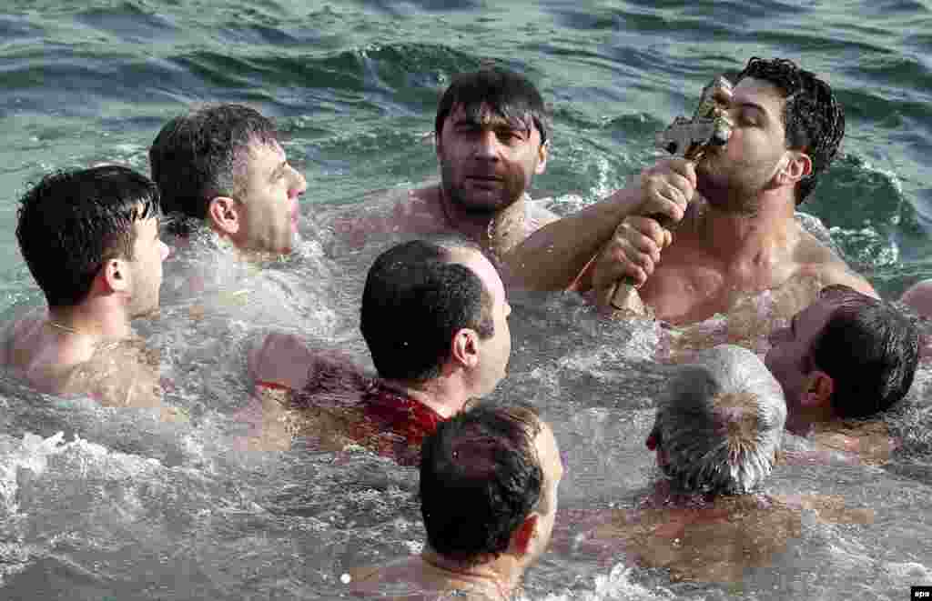 Greek Orthodox swimmers kiss a wooden crucifix in the chilly waters of the Bosphorus, where it was thrown during an Epiphany Day ceremony in Istanbul, Turkey. (epa/Sedat Suna)