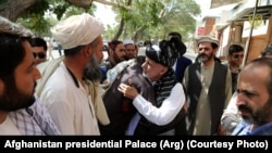 President Ashraf Ghani (center) is greeted during his trip to Ghazni Province on August 17.