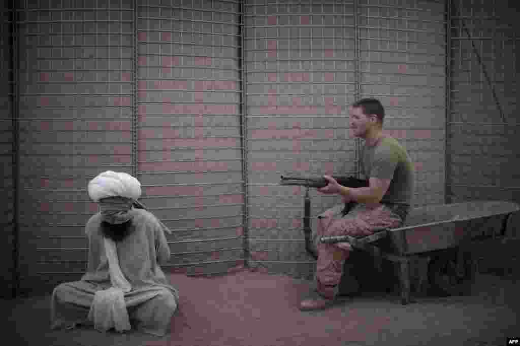 A U.S. marine guards a detainee at a U.S. Marine base in Marjah, in Helmand Province, in 2010.