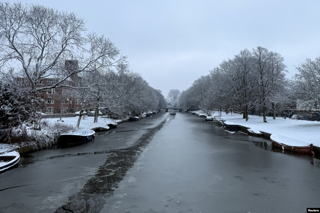 Një kanal lumi i mbuluar me akull në Amsterdam, mes ndërprerjeve në trafikun ajror, hekurudhor dhe rrugor si pasojë e borës. Qindra fluturime u anuluan dhe trenat ndaluan në Holandë, më 5 janar 2026.