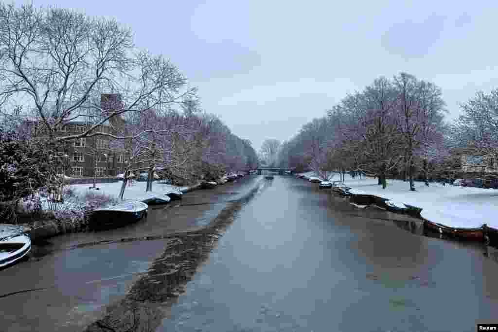 Zaleđeni riječni kanal u Amsterdamu, usred prekida u avio, željezničkom i drumskom saobraćaju zbog snijega. Stotine letova su otkazane, a vozovi zaustavljeni u Nizozemskoj, 5. januara 2026.