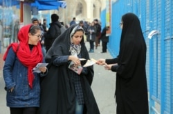 Представительница одной из многочисленных женских государственных исламских организаций Ирана убеждает прохожих участвовать в голосовании. Тегеран, 14 февраля 2020 года
