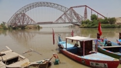 A man wades next to his boat along the Indus River near the Lansdowne Bridge in Sukkur, in Pakistan's southern Sindh Province on April 28. 