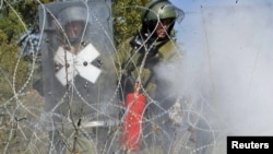 German KFOR soldiers try to extinguish a fire at the closed Serbia-Kosovo border crossing of Jarinje on September 27.