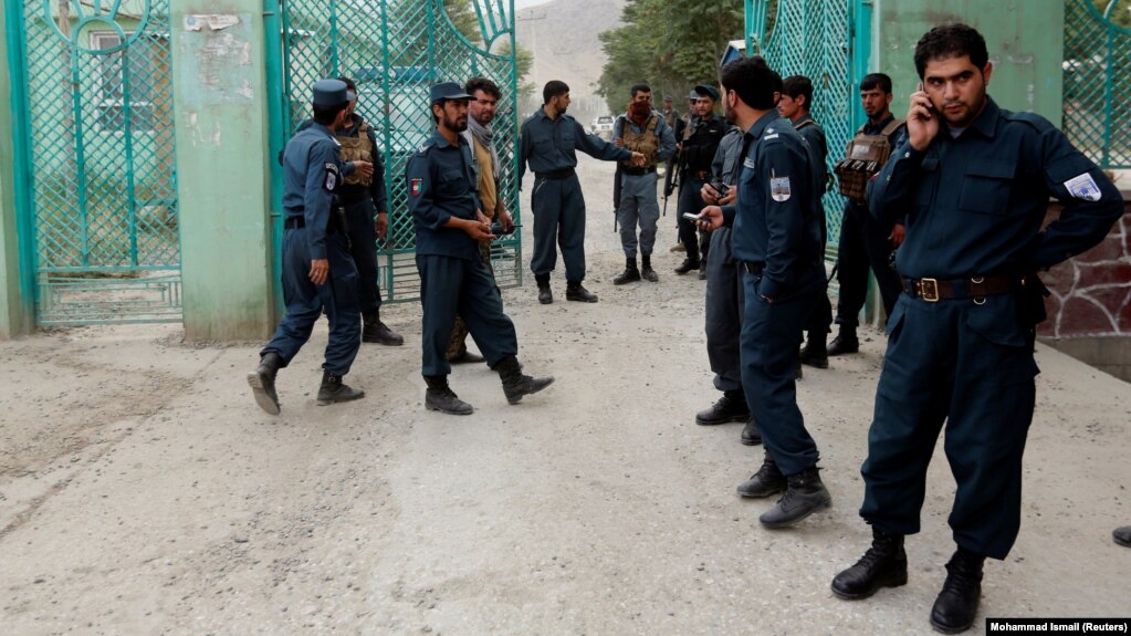 Afghan policemen stand guard near the site of the blasts in Kabul on June 3.