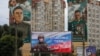 Білборд на російську військово-патріотичну тематику, встановлений перед житловими будинками з муралами, що зображують радянських полководців Костянтина Рокоссовського та Олександра Василевського. Анексований Крим, Сімферополь, 15 вересня 2026 року