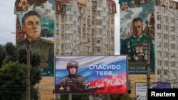 Білборд на російську військово-патріотичну тематику, встановлений перед житловими будинками з муралами, що зображують радянських полководців Костянтина Рокоссовського та Олександра Василевського. Анексований Крим, Сімферополь, 15 вересня 2026 року