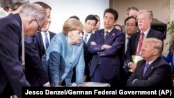 دونالد ترامپ (نشسته) در حال گوش دادن به سخنان آنگلا مرکل (صدراعظم آلمان) و سایر رهبران گروه هفت.