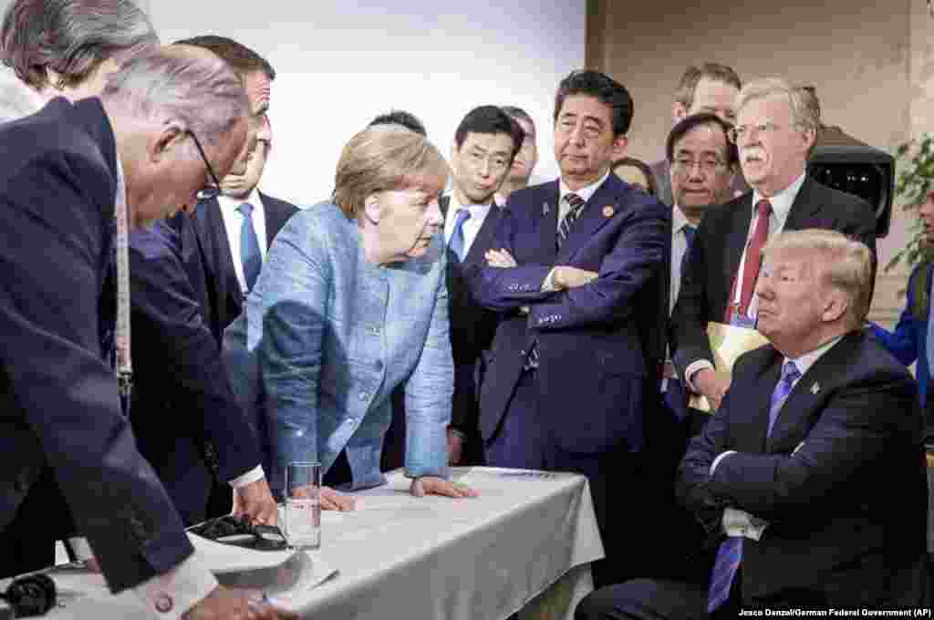 In this photo made available by the German Federal Government, German Chancellor Angela Merkel (center) speaks with U.S. President Donald Trump (seated) during the G7 summit in Quebec, Canada, on June 9. Trump angered allies by leaving the summit early and refusing to endorse a final communique that he had originally agreed to be a part of. (Jesco Denzel/German Federal Government via AP)