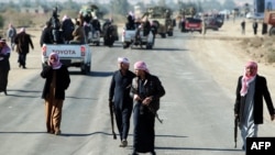 Armed relatives and tribe members protect the road during a funeral procession for deputy Ayfan Saadun al-Essawi of the Al-Iraqiyah bloc in the western town of Fallujah on January 16. Essawi was killed by a suicide bomber.