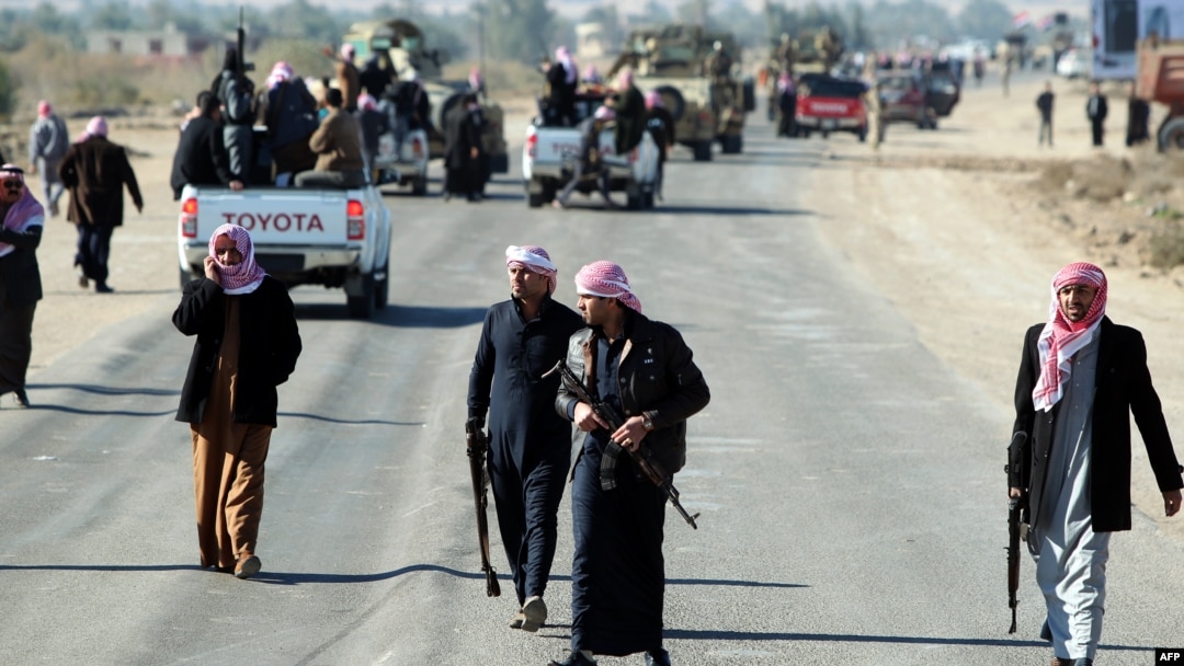 Armed relatives and tribe members protect the road during a funeral procession for deputy Ayfan Saadun al-Essawi of the Al-Iraqiyah bloc in the western town of Fallujah on January 16. Essawi was killed by a suicide bomber.