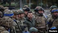 President Volodymyr Zelenskiy poses for pictures with Ukrainian soldiers as he visits the town of Izyum on September 14.