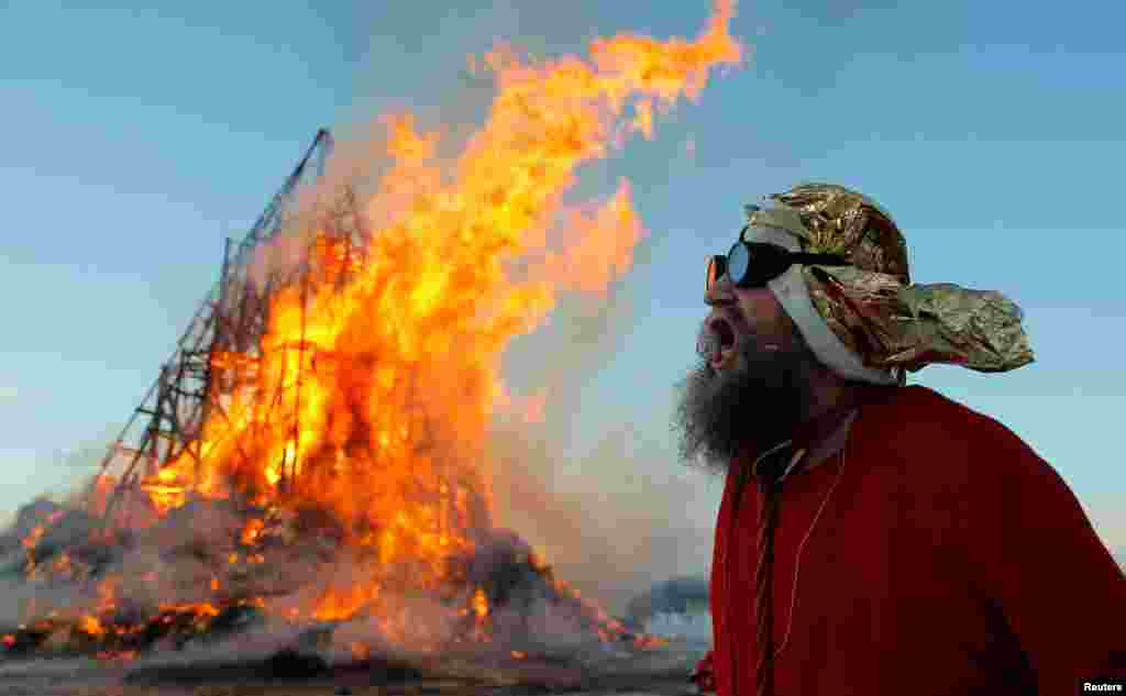 Эксцентричный российский художник Герман Виноградов сжигает масленичную пирамиду. Калужская область, Россия