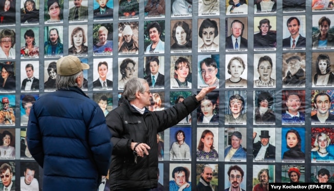 People look at portraits of victims of the Nord-Ost crisis during a gathering outside the Dubrovka Theater in Moscow in October 2020. Terror Attacks