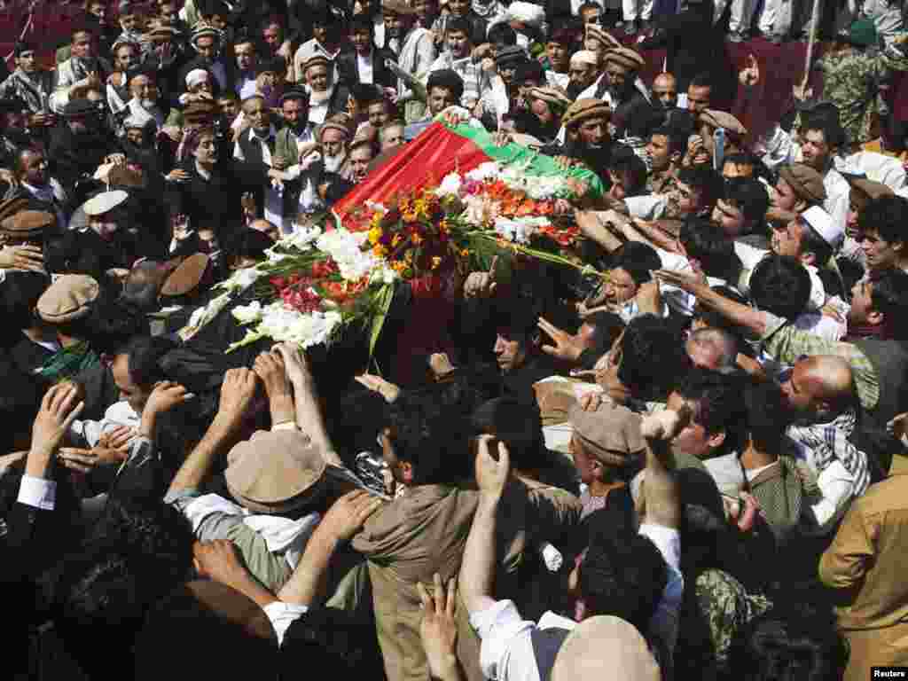 People carry the coffin of assassinated former Afghan President Burhanuddin Rabbani during his burial ceremony in Kabul on September 23. (Photo taken by Ahmad Masood for Reuters)