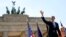 U.S. President Barack Obama waves as he arrives with German Chancellor Angela Merkel to give his speech in front of the Brandenburg Gate on Pariser Platz in Berlin on June 19.