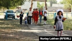 Школьники и их родители идут на линейку в День знаний.