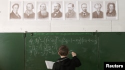 Russia -- A pupil writes on the blackboard as he attends a mathematics lesson at a local school based in the remote village of Bolshie Khutora, 14Mar2012