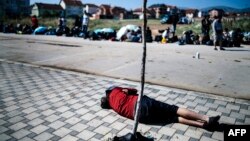 A migrant rests near the police station in the southern Serbian town of Presevo, near the border with Macedonia, on July 2.
