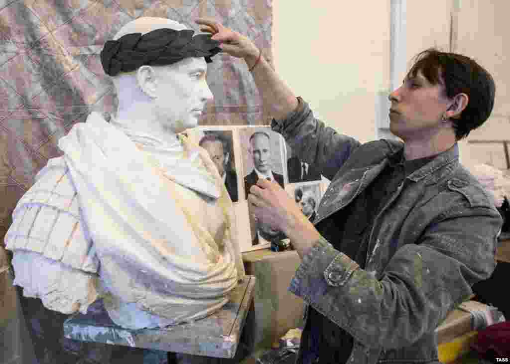 Sculptor Pavel Greshnikov finalizes a statue of Russian President Vladimir Putin in the style of a Roman emperor in the workshop of the Academy of Arts in St. Petersburg. The bust, which will be cast in bronze, is due to be unveiled outside a metro station on the northern outskirts of St. Petersburg on May 9, the holiday commemorating the Soviet victory in World War II. (TASS/Sergei Konkov)