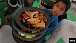 Dječak nosi hranu koja će se podijeliti prolaznicima u Karačiju, u Pakistanu, za večernji obrok kojim se prekida dnevni post tokom mjeseca ramazana.