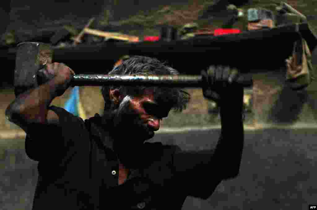 A Pakistani laborer uses a sledgehammer as he works at an iron factory in Karachi. (AFP/Asif Hassan)