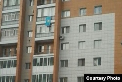 Казахстанский флаг на балконе Жандоса Курманбаева, из-за которого ему выписали штраф. Астана, февраль 2015 года