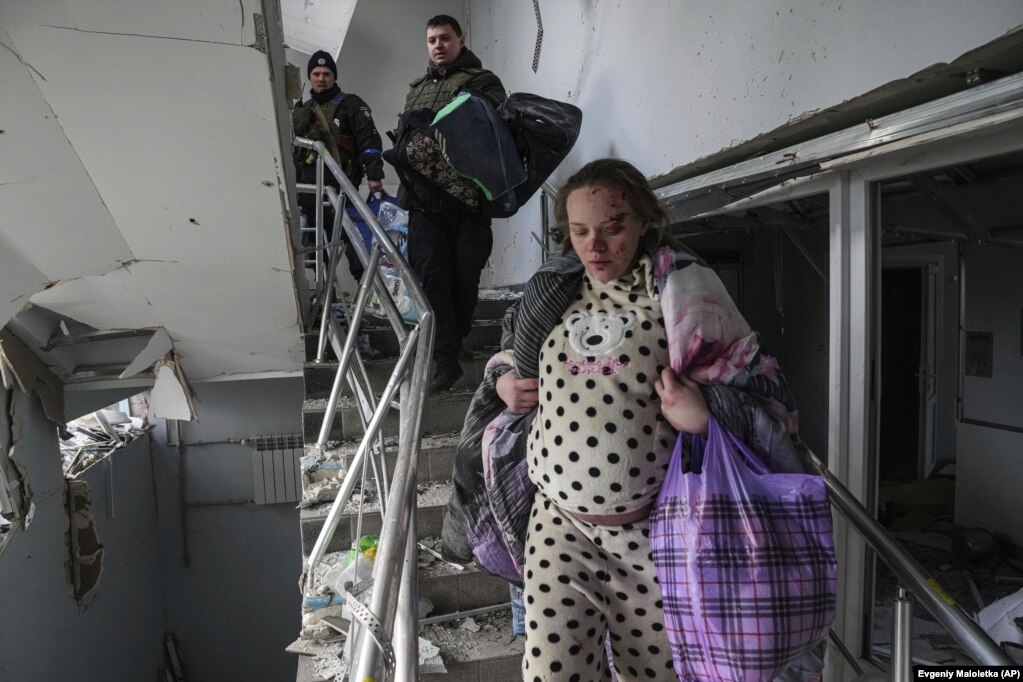 Një grua e lënduar shtatzënë duke zbritur shkallët, në një ndërtesë të shkatërruar të spitalit të lindjes, pas sulmeve ruse, në Mariupol, më 9 mars.