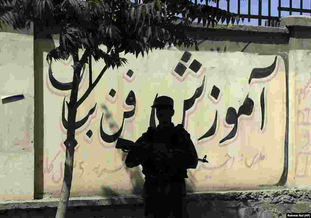 A policeman stands guard near the site of a deadly suicide attack in the Afghan capital, Kabul, on June 11. (AP/Rahmat Gul)