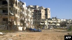 Syria -- Destroyed vehicles and buildings are seen after shelling by Syrian military forces in the Inshaat neighborhood of the restive city of Homs, 05Mar2012