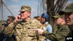 اعضای ارتش اوکراین و روسیه و ناظران سازمان همکاری و امنیت اروپا در حال رصد درگیری‌ها در یابونکی، در اطراف فرودگاه دونتسک