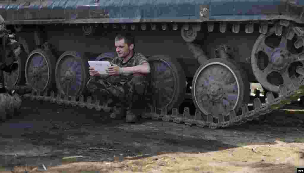 Український вояк під час перепочинку на бойових позиціях в районі Артемівська Донецької області, 26 травня 2015 року