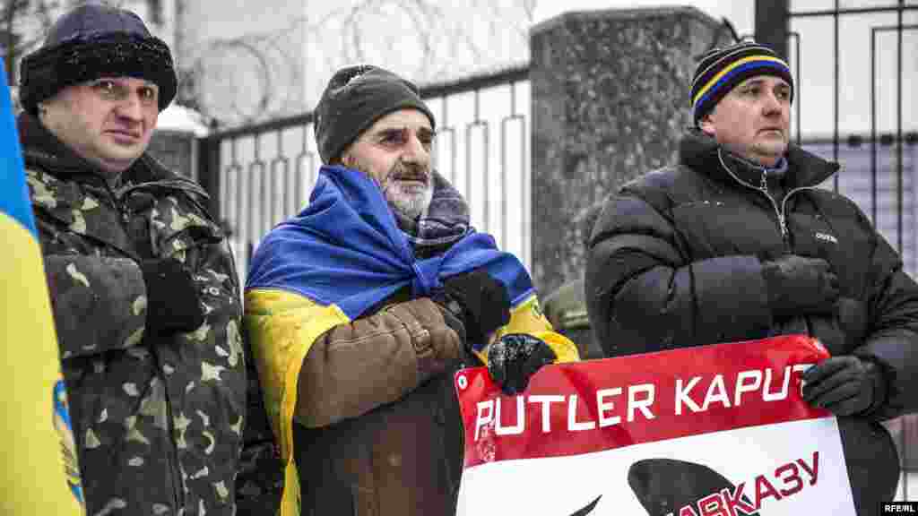 Чеченцы и грузины под флагом Украины держат руку на сердце, когда звучит гимн