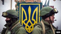 Так звані «зелені чоловічки» стоять на КПП біля в’їзду до української військової частини в селищі Перевальне неподалік Сімферополя під час операції захоплення Криму російськими військами. Крим, 2 березня 2014 року