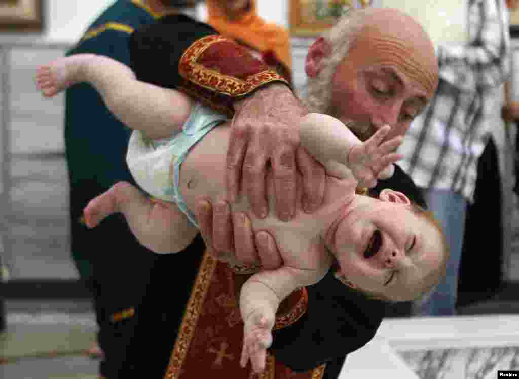 A Georgian baby is baptised during a mass baptism ceremony in Tbilisi. (Reuters/David Mdzinarishvili)