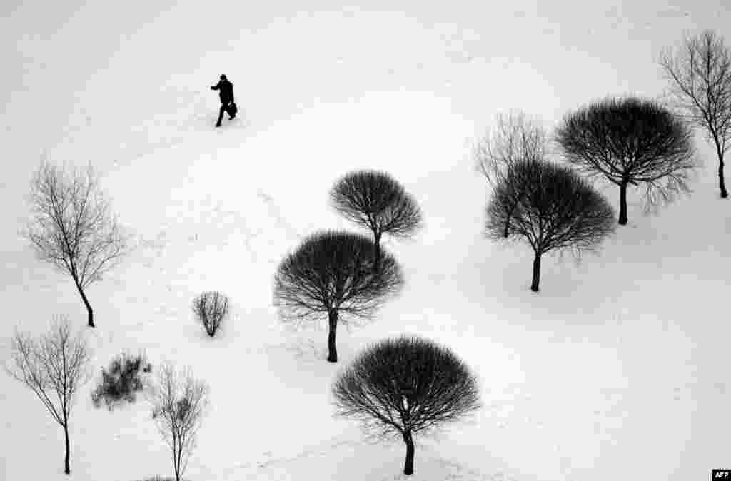 A man crosses a snow-covered park in Minsk. (AFP/Sergei Gapon)