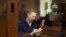 Russian opposition leader Aleksei Navalny stands inside a glass cell during a court hearing in Moscow on February 12.