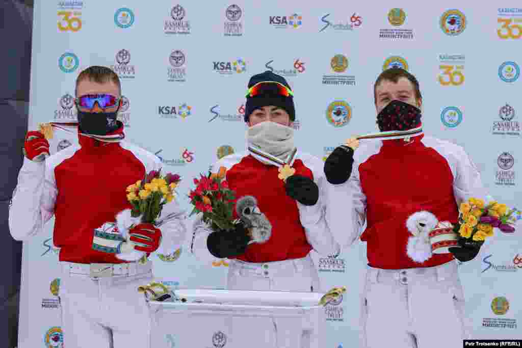 Russian skiers Pavel Krotov (left), Lyubov Nikitina, and Maksim Burov show off their gold medals.