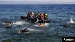 Afghan and Syrian refugees struggle to swim from a dinghy with a broken engine that drifts out of control to a rocky beach on the Greek island of Lesbos after crossing a part of the Aegean Sea from Turkey (file photo).