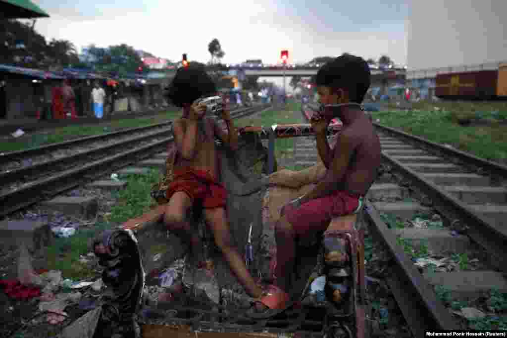 Children pretend to take photos with a broken camera in Dhaka, Bangladesh. (Reuters/Mohammad Ponir Hossain)